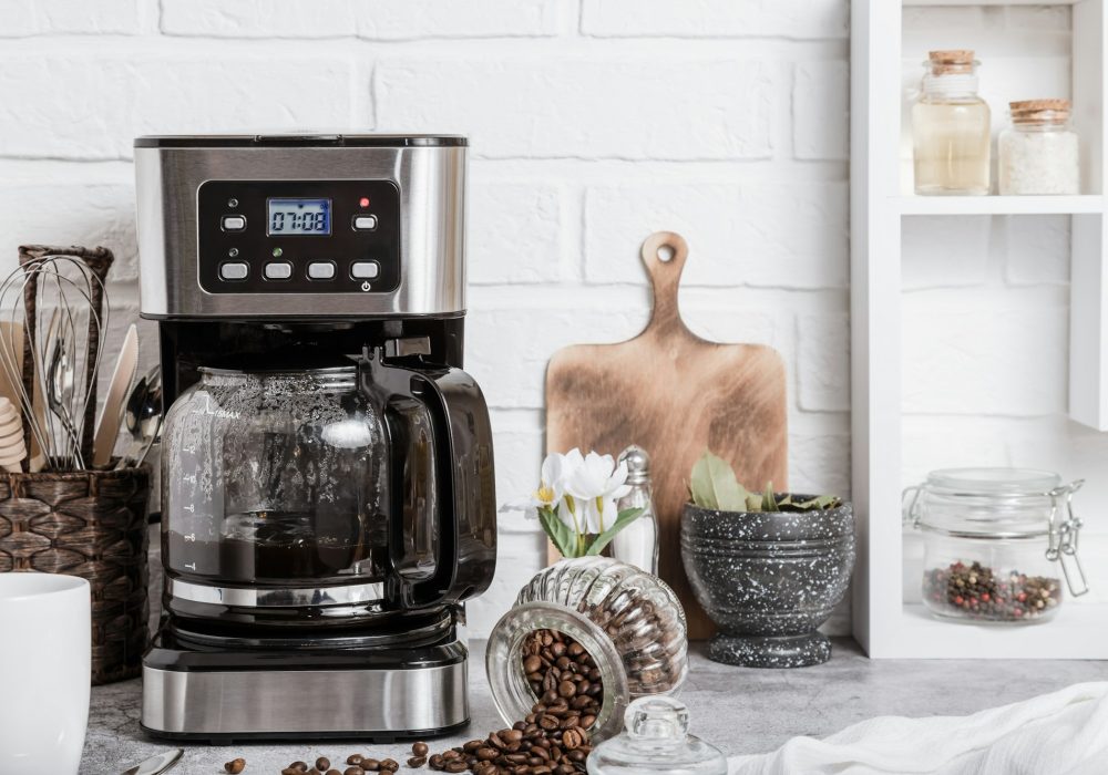 A Black Drip Electric Coffee Machine with a Glass Teapot Brews a Morning Drink. Household Appliances