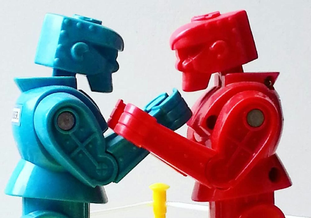 Side view of red and blue toy boxing figures against white background