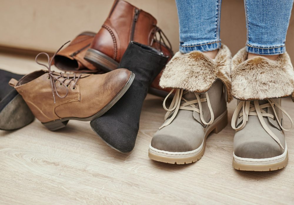 Woman chooses comfortable shoes among a bunch of different pairs